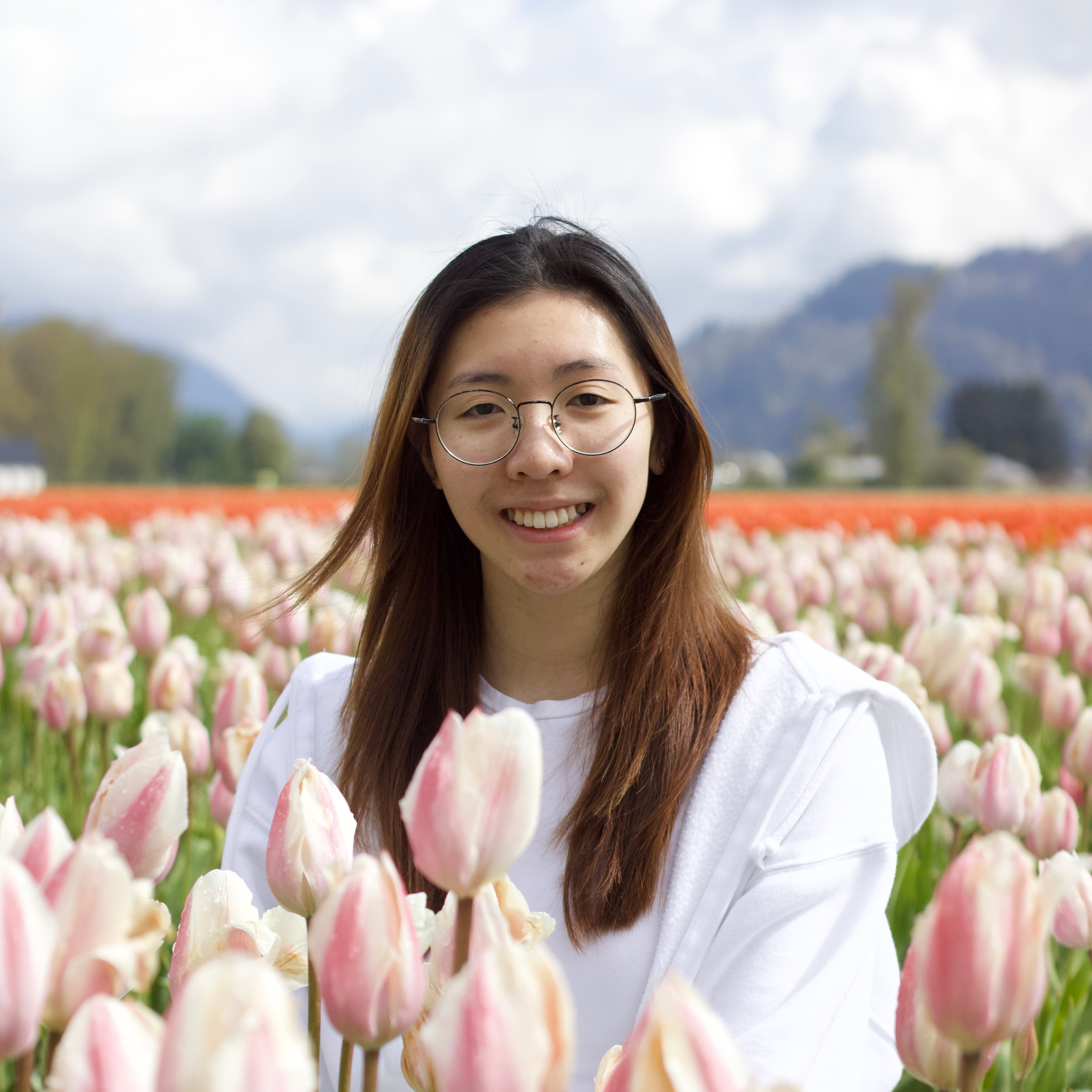 headshot of Queenie in a flower field